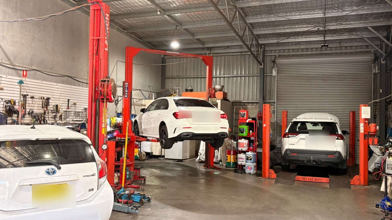 Real Hancock Automotive workshop with vehicles on service hoists